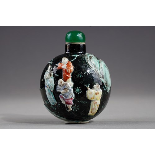 Snuff bottle porcelain molded with eight immortals on a dark green background